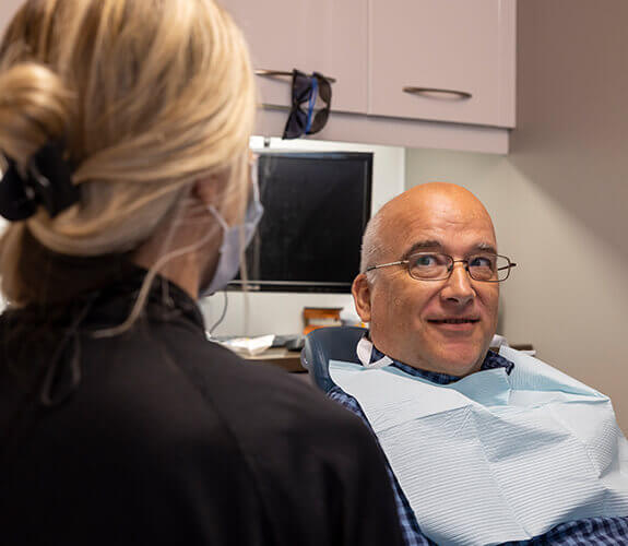Man laughing with dentist during preventive dentistry checkup